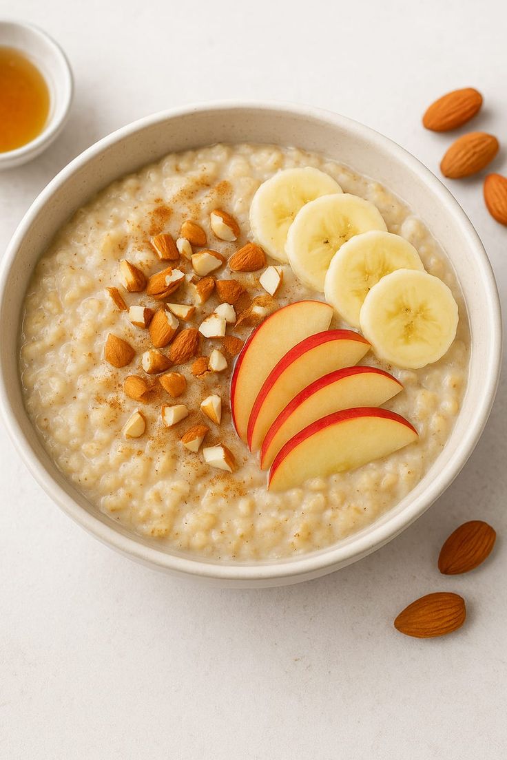 Plant-based oat porridge breakfast with banana, apple and almonds