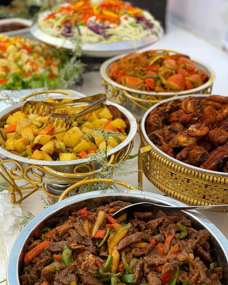 Elegant buffet catering setup with gold chafing dishes, stir-fry and grilled chicken